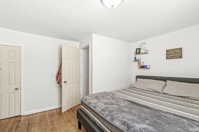 bedroom featuring hardwood / wood-style flooring and a textured ceiling