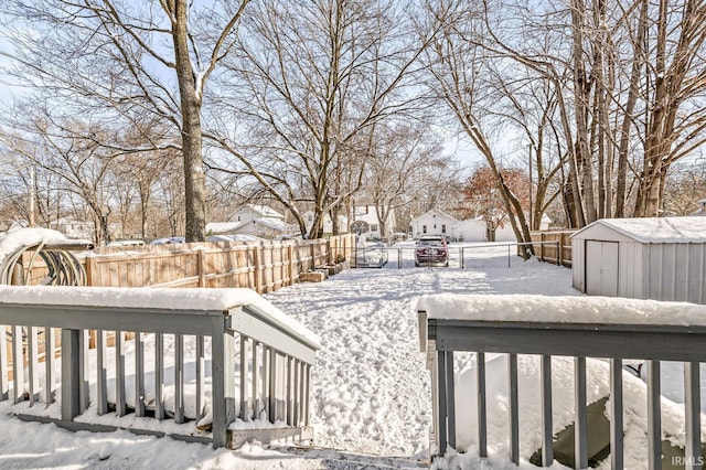 yard layered in snow featuring a storage unit