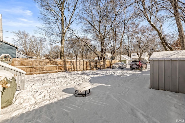 yard layered in snow featuring a storage shed