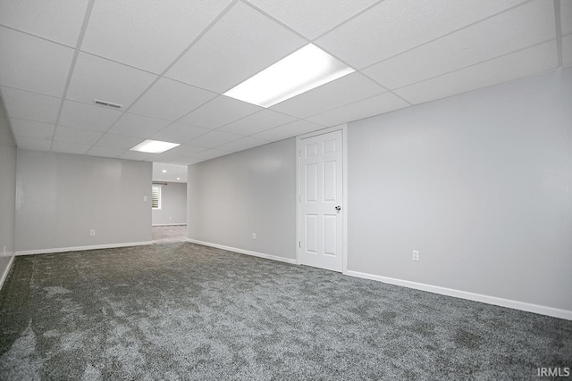 basement with a drop ceiling and dark carpet