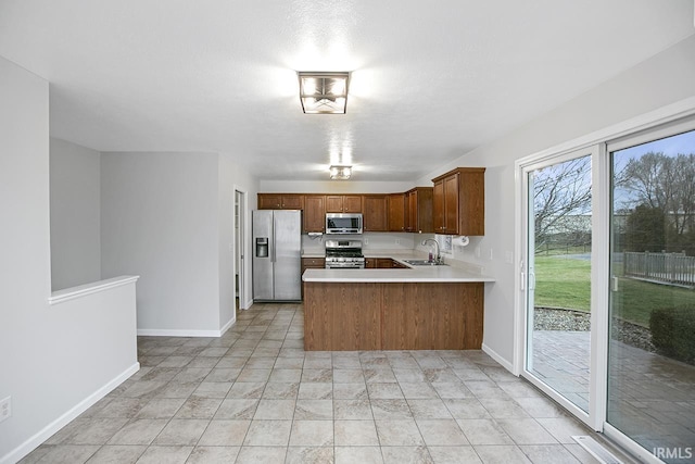 kitchen with kitchen peninsula, stainless steel appliances, and sink