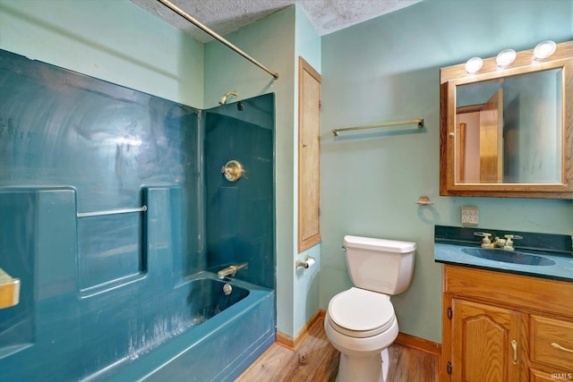 full bathroom with tub / shower combination, vanity, a textured ceiling, hardwood / wood-style floors, and toilet