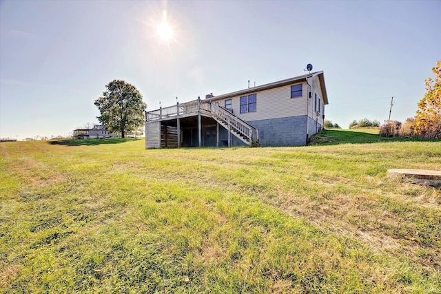 back of property with a wooden deck and a yard