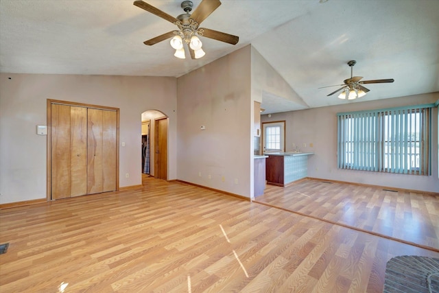 unfurnished living room with ceiling fan, light hardwood / wood-style flooring, and vaulted ceiling