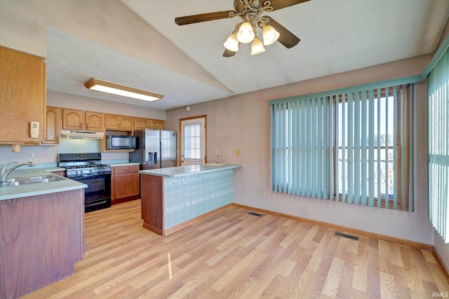 kitchen featuring kitchen peninsula, sink, black appliances, and light hardwood / wood-style floors