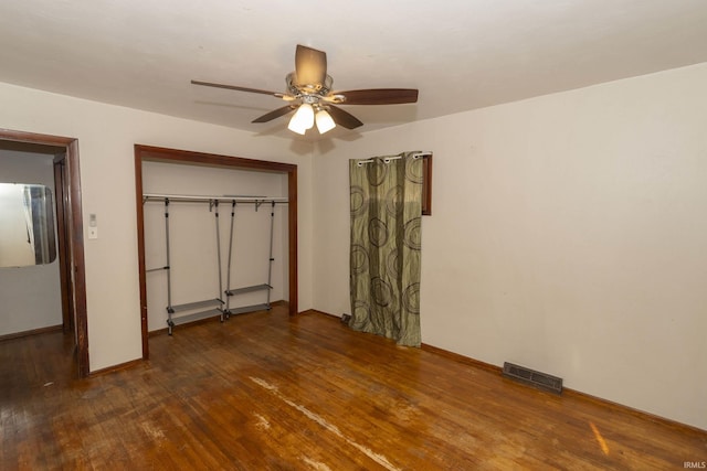 unfurnished bedroom with ceiling fan, a closet, and dark wood-type flooring