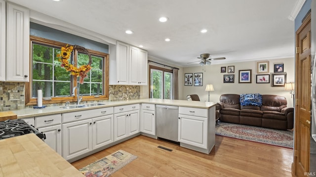 kitchen featuring dishwasher, kitchen peninsula, white cabinetry, and sink