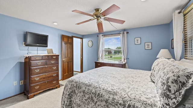 carpeted bedroom featuring a textured ceiling and ceiling fan