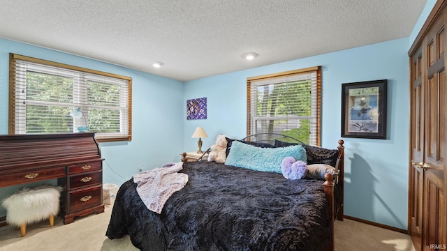 carpeted bedroom with a textured ceiling and a closet