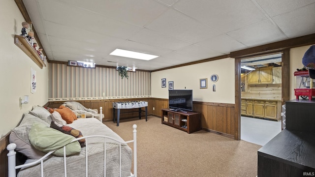 carpeted living room featuring a drop ceiling and crown molding