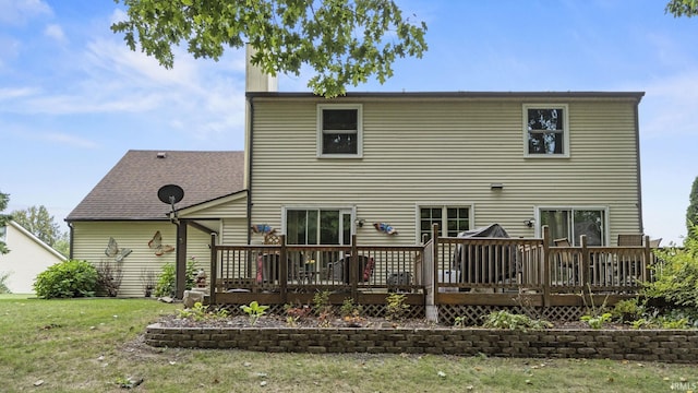 rear view of house featuring a deck and a yard