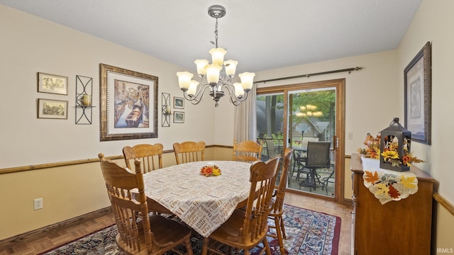 dining area featuring a notable chandelier and parquet floors