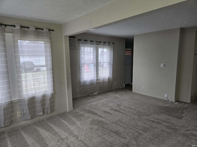 carpeted empty room featuring a textured ceiling