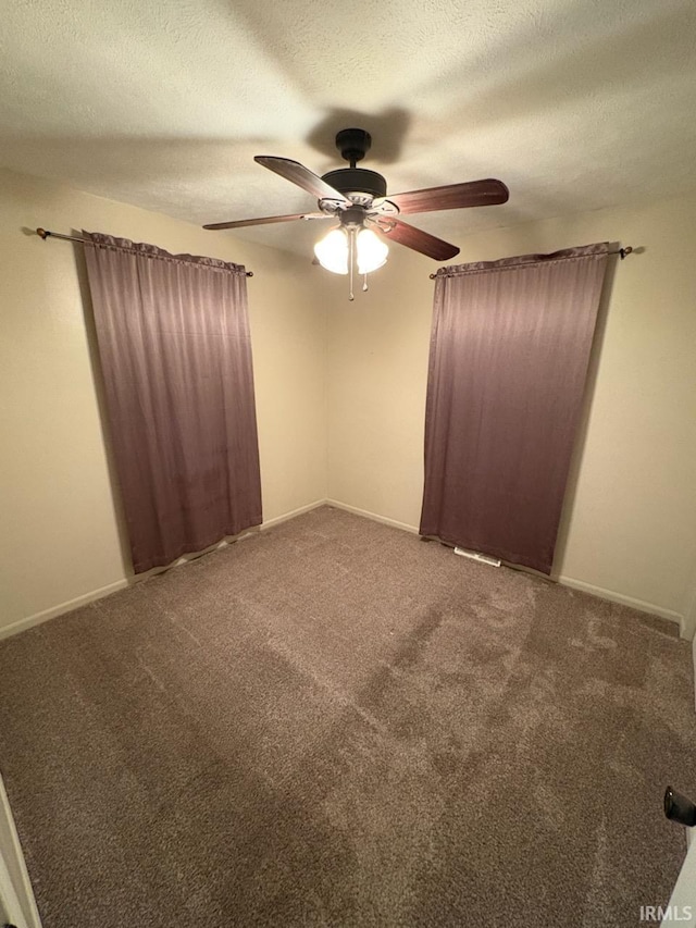 carpeted empty room featuring ceiling fan and a textured ceiling