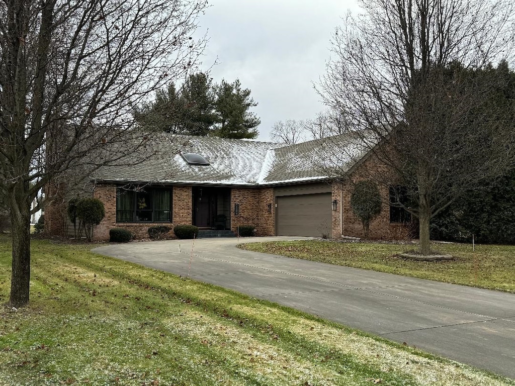 single story home featuring a garage and a front lawn