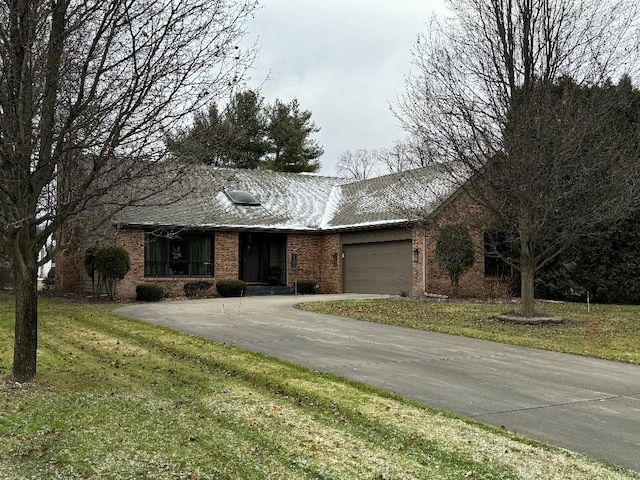 single story home featuring a garage and a front lawn