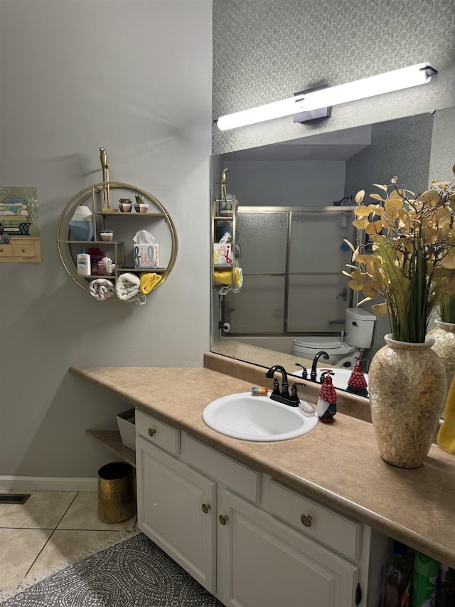 bathroom with tile patterned flooring, vanity, and combined bath / shower with glass door