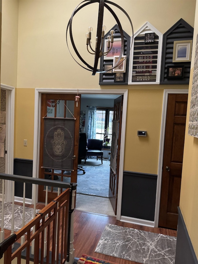 corridor featuring hardwood / wood-style floors and an inviting chandelier