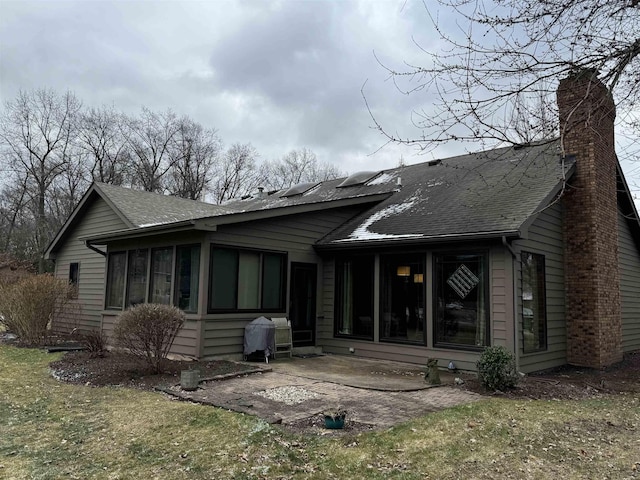 rear view of property with a lawn and a patio