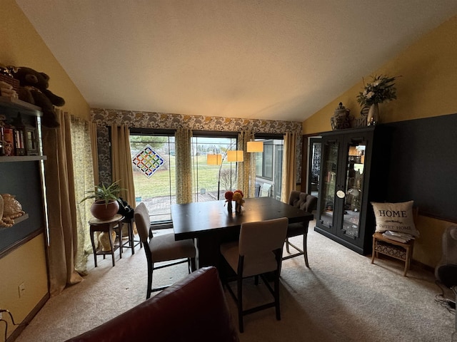 dining space featuring carpet and vaulted ceiling