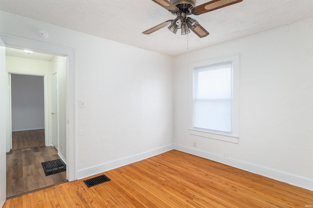 unfurnished room with ceiling fan, hardwood / wood-style floors, and a textured ceiling