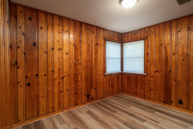 spare room featuring hardwood / wood-style floors and wooden walls