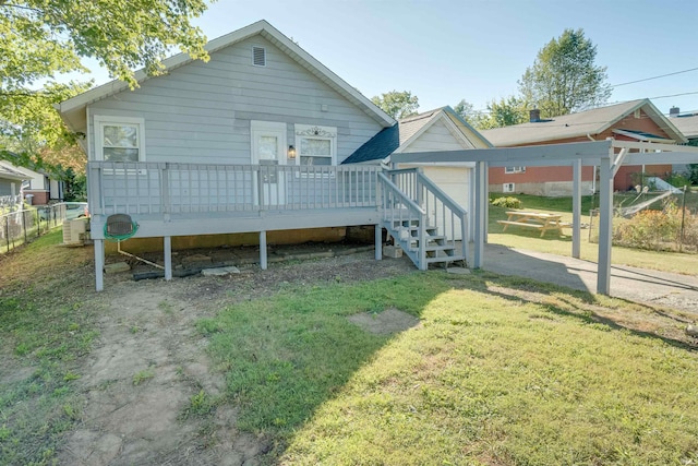 back of property with a lawn and a deck