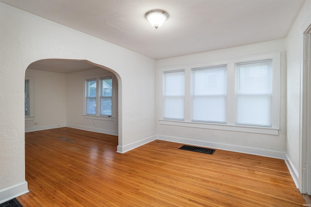 unfurnished room featuring hardwood / wood-style floors and plenty of natural light