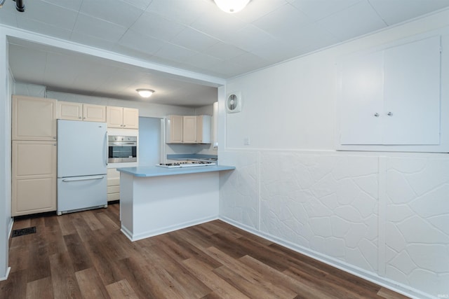 kitchen with kitchen peninsula, dark hardwood / wood-style flooring, and white appliances