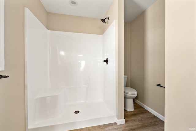 bathroom with walk in shower, wood-type flooring, and toilet