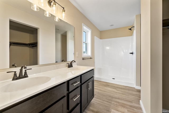 bathroom featuring hardwood / wood-style floors, vanity, and walk in shower