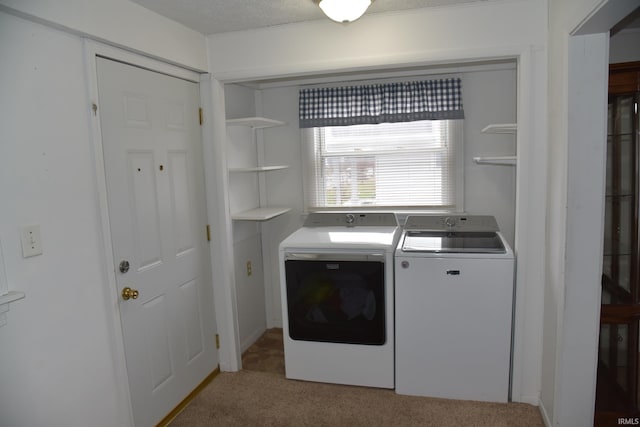 laundry area with light carpet, independent washer and dryer, and a textured ceiling