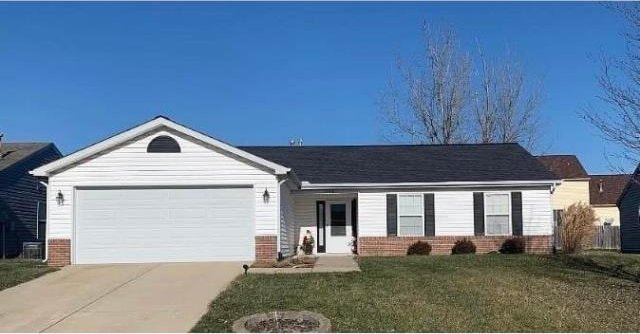 ranch-style home with a garage and a front lawn