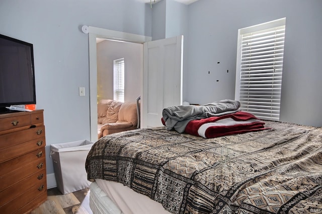 bedroom with light hardwood / wood-style floors and multiple windows