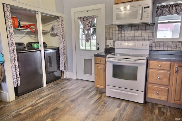 kitchen with washing machine and clothes dryer, decorative backsplash, dark hardwood / wood-style flooring, and white appliances