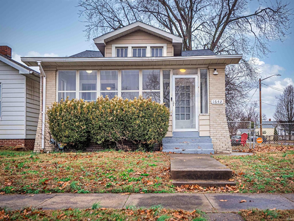 bungalow-style house featuring a sunroom