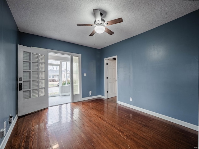 empty room with ceiling fan, dark hardwood / wood-style flooring, and a textured ceiling