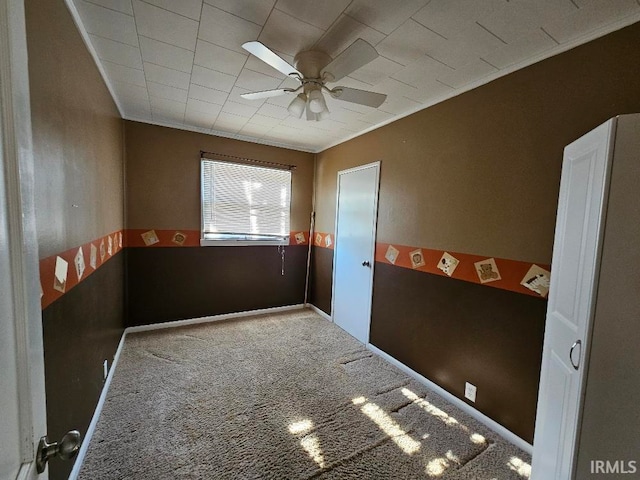 unfurnished room with carpet floors, ceiling fan, and crown molding