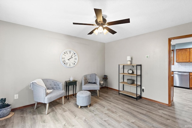 sitting room with ceiling fan and light hardwood / wood-style flooring