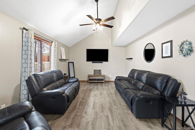 living room featuring ceiling fan, wood-type flooring, and lofted ceiling