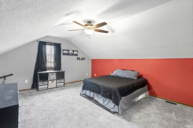 bedroom featuring a textured ceiling, ceiling fan, carpet floors, and vaulted ceiling