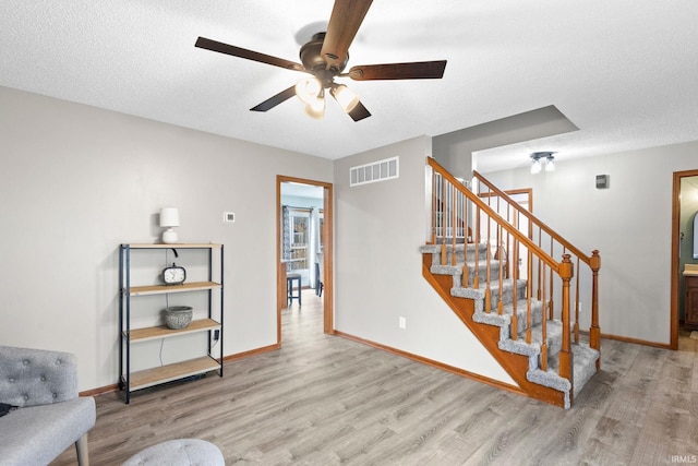 interior space featuring ceiling fan, hardwood / wood-style floors, and a textured ceiling