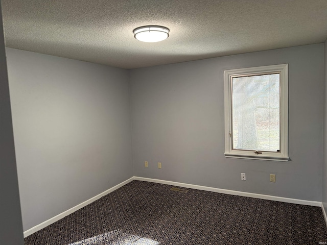 carpeted empty room with a textured ceiling