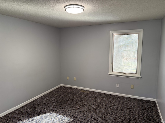 carpeted empty room featuring a textured ceiling