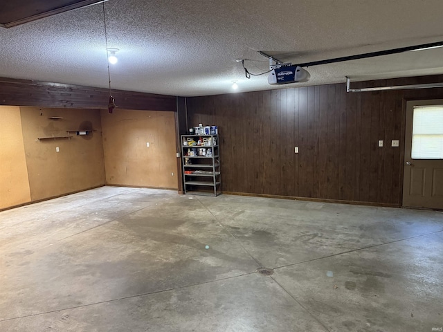 garage with a garage door opener and wooden walls