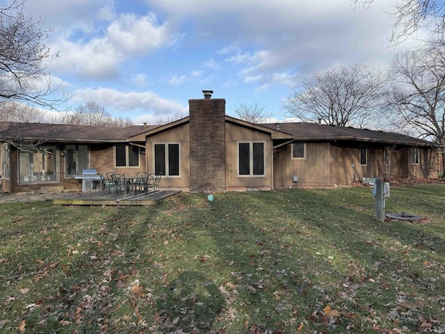 rear view of house with a lawn and a sunroom