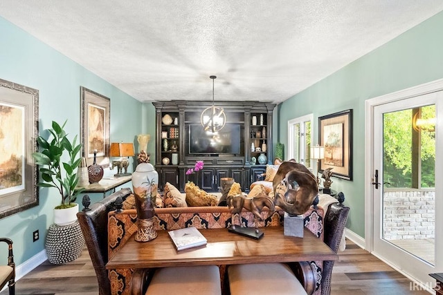 living room featuring a chandelier, wood-type flooring, and a textured ceiling