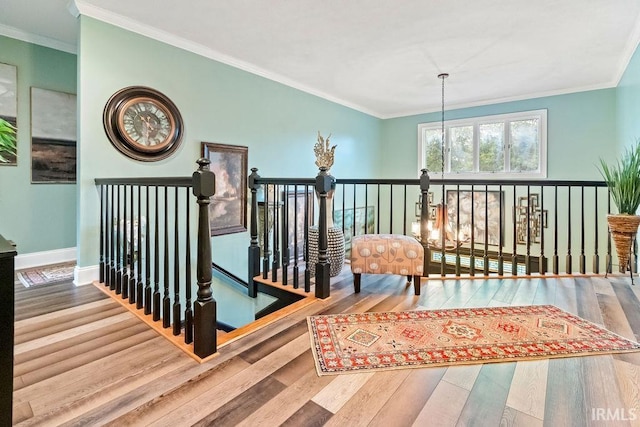 corridor featuring a chandelier, wood-type flooring, and crown molding