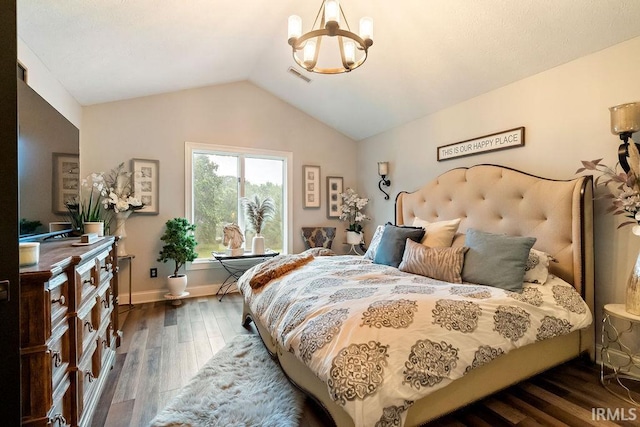 bedroom with lofted ceiling, dark hardwood / wood-style floors, and a notable chandelier