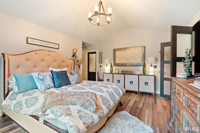 bedroom with a chandelier, wood-type flooring, and lofted ceiling